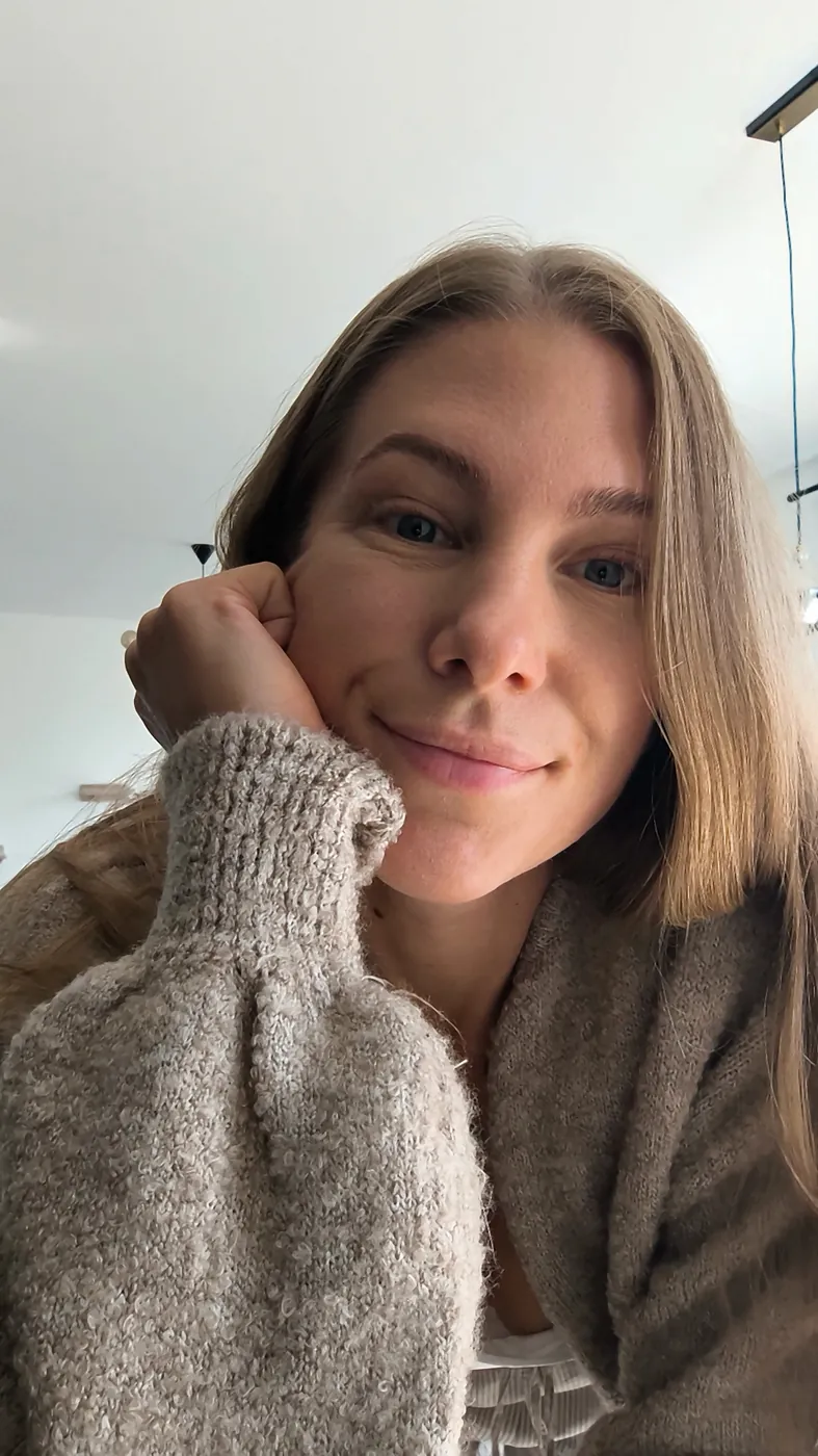 Porträt von Helen Fritzsche im beigen Strickpullover, die Hand an der Wange